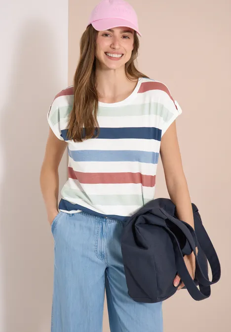 Vrouw met gestreept T-shirt, brede spijkerbroek en donkerblauwe schoudertas.