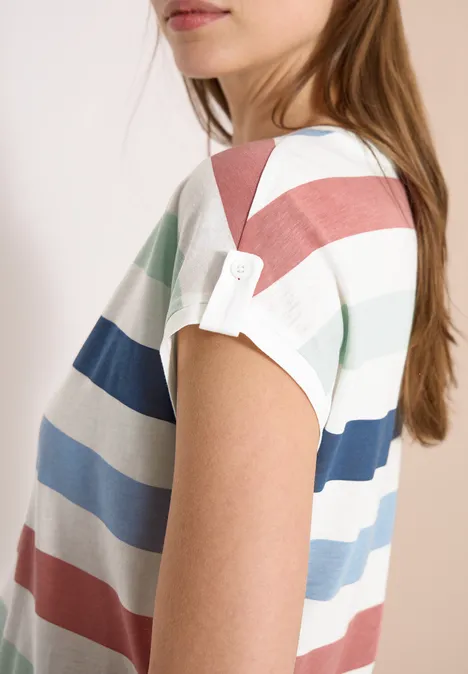Zijaanzicht van een persoon in een t-shirt met korte mouwen en brede pastelstrepen in wit, mintgroen, blauw en roze.
