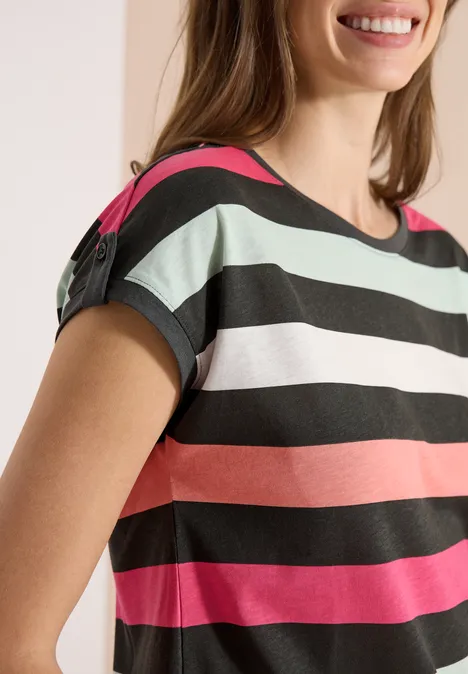 Femme en t-shirt à manches courtes avec rayures horizontales noires, blanches, menthe, corail et rose.