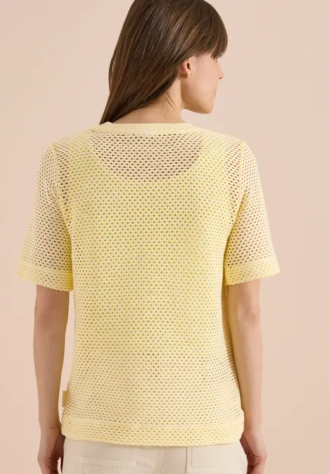 Shirt met ronde hals in ajour look buttermilk yellow Vrouw van achteren in een geel, kort mouwen mesh shirt tegen neutrale achtergrond.