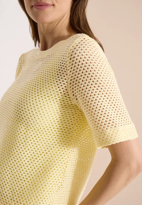 Shirt met ronde hals in ajour look buttermilk yellow Close-up van een vrouw in een geel gehaakt shirt met korte mouwen.