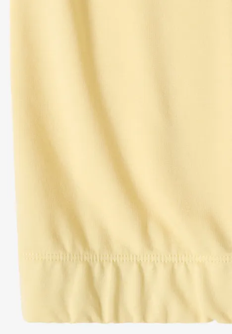 Close-up van een lichtgeel, licht geplooid zoom van stof.