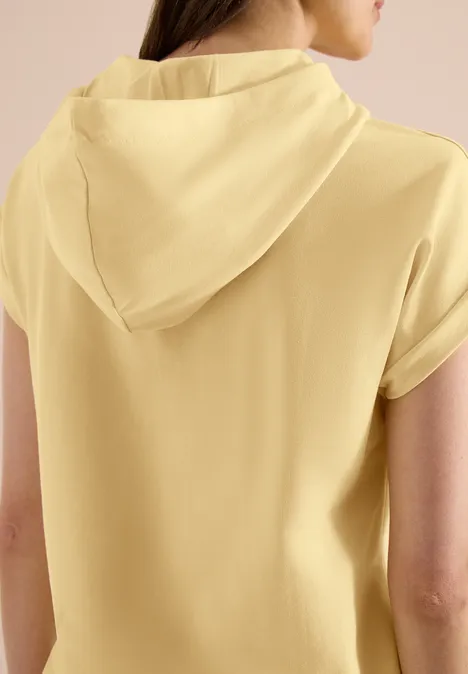 Achteraanzicht van persoon in geel, kapuzen-T-shirt