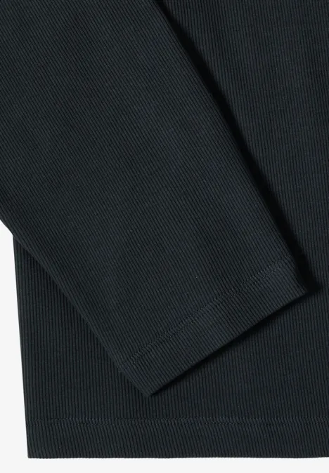 Close-up van een gestructureerde zwarte stof, deel van een langarmshirt.