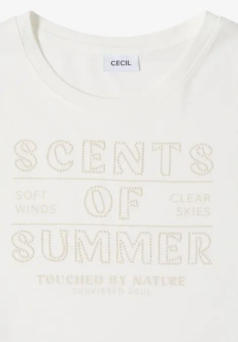 Wit T-shirt met gouden opdruk ‘SCENTS OF SUMMER’ en de teksten ‘Soft winds’, ‘Clear skies’ en ‘Touched by nature’.