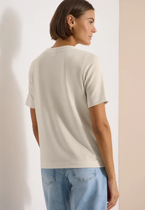 Gestreept shirt pearl beige Rugaanzicht van een persoon met een beige T-shirt en lichte spijkerbroek voor een neutrale achtergrond.