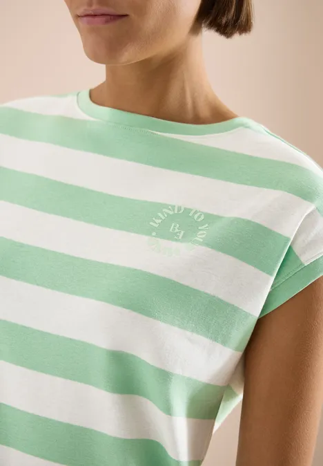 Eine Nahaufnahme einer Person in einem T-Shirt mit weißen und mintgrünen Streifen und kleinem Logo.