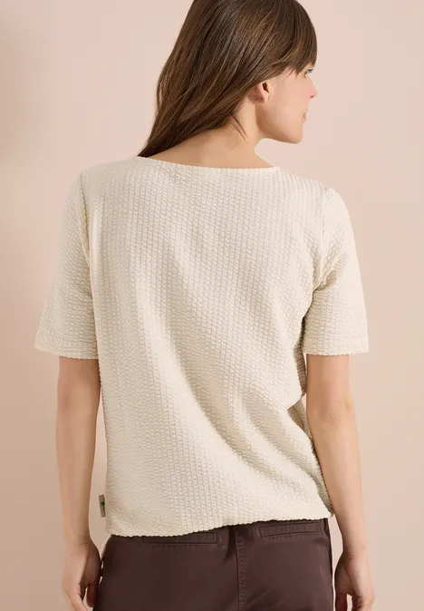Shirt in seersucker stof pearl beige Achteraanzicht van een vrouw in een beige wafelstof-T-shirt met korte mouwen voor een lichte achtergrond.