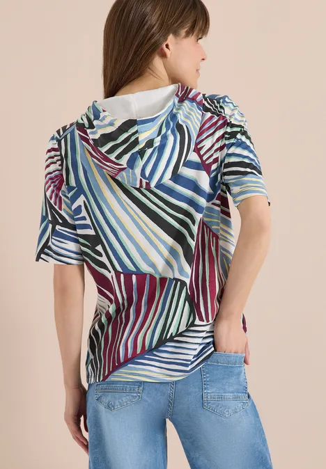 Hoodie shirt met print palm breeze green Vrouw van achteren in een gestreept, kleurrijk shirt en een blauwe spijkerbroek.