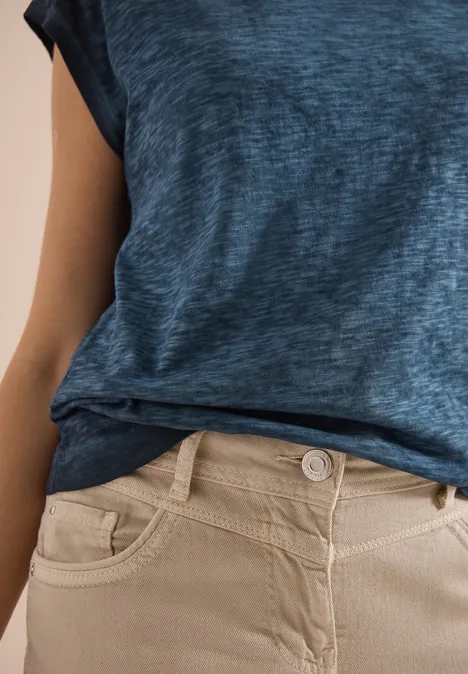 Blau meliertes T-Shirt und beige Hose am Bund.