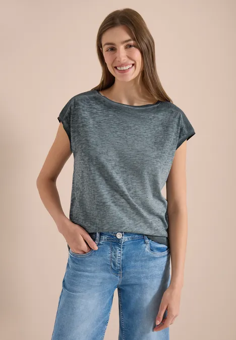 T-Shirt mit Boatneck im Garment-Dye-Look volcanic grey Eine Person trägt ein graues T-Shirt und blaue Jeans, steht vor neutralem Hintergrund.