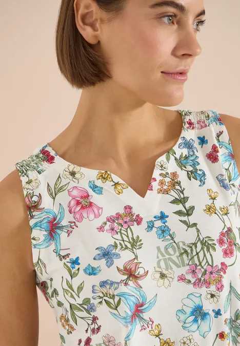 Top mit Split Neck und Raffung light alabaster white Frau in ärmellosem, weißem Top mit buntem Blumenmuster und V-Ausschnitt