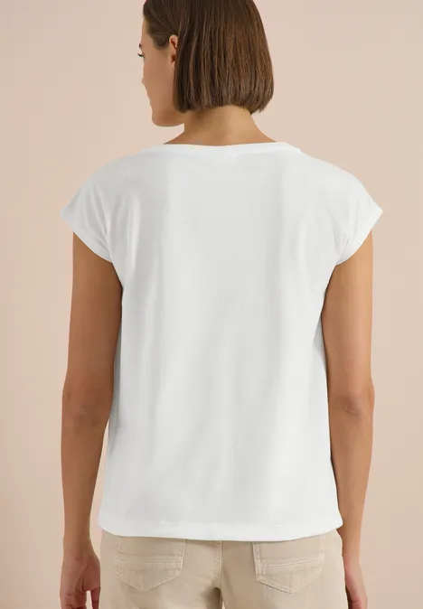 Eine von hinten fotografierte Person trägt ein schlichtes weißes T-Shirt.