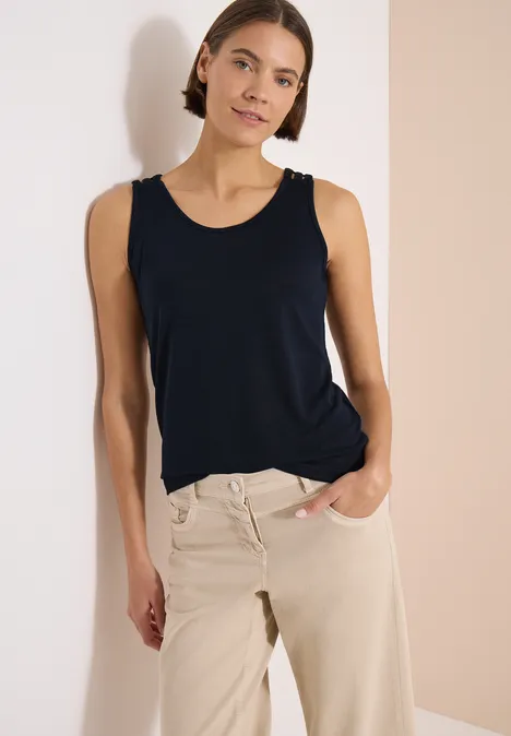 Top avec col en V arrondi et détail tressé universal blue Une personne mince porte un débardeur bleu foncé et un pantalon beige sur fond clair.