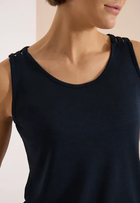 Top avec col en V arrondi et détail tressé universal blue Une femme porte un débardeur bleu marine, cadrage sur le cou et les épaules.