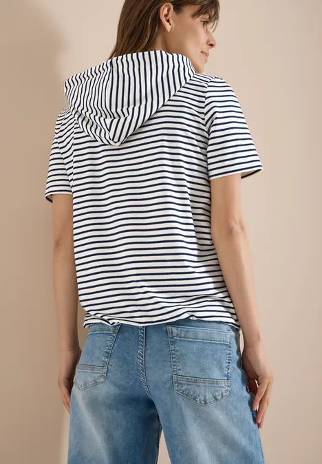 Kurzarm Shirt mit Kapuze und Glitzer vanilla white Frau von hinten in gestreiftem T-Shirt mit Kapuze und blauen Jeans.