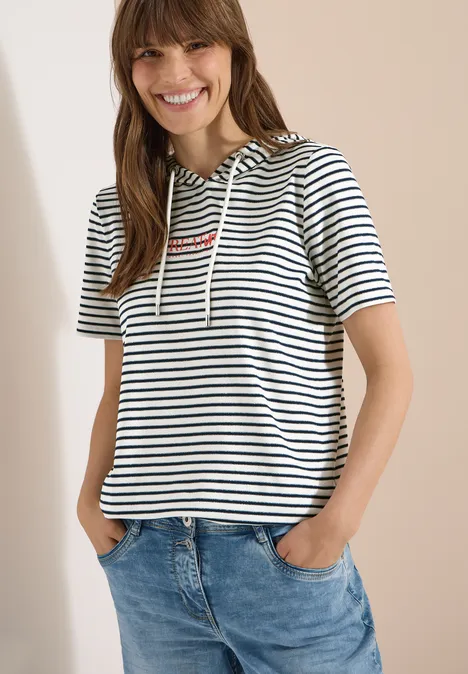 Kurzarm Shirt mit Kapuze und Glitzer vanilla white Frau in gestreiftem Kurzarm-Hoodie mit Kapuze und Jeans.