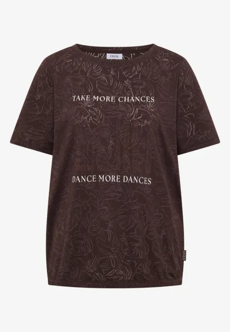 Braunes T-Shirt mit floralen Mustern und weißem Text „Take more chances, dance more dances.“