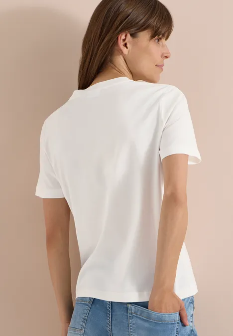 Achteraanzicht van persoon in eenvoudige witte t-shirt voor een beige achtergrond.