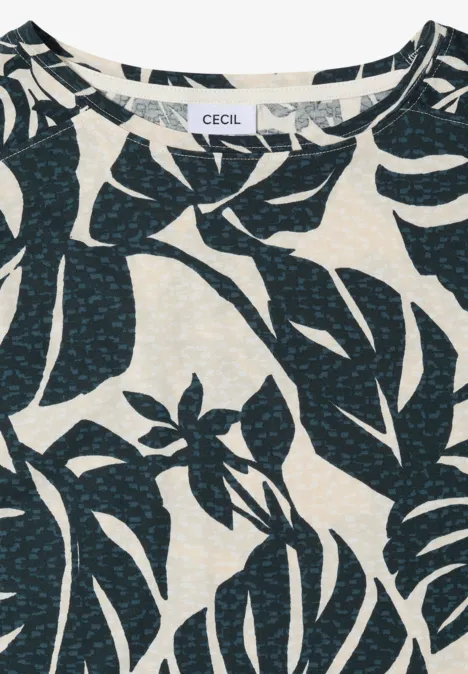 Helle Bluse mit dunkelblauem Tropenblatt-Print auf cremefarbenem Hintergrund.
