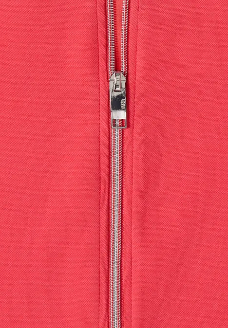 Rotes Kleidungsstück aus Stoff mit silbernem Reißverschluss in der Mitte