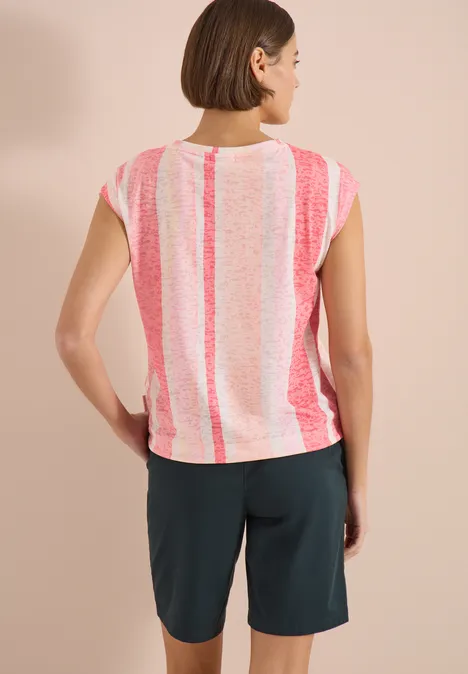 Vue de dos d’une femme en t-shirt rayé rose et blanc et short foncé sur fond neutre.