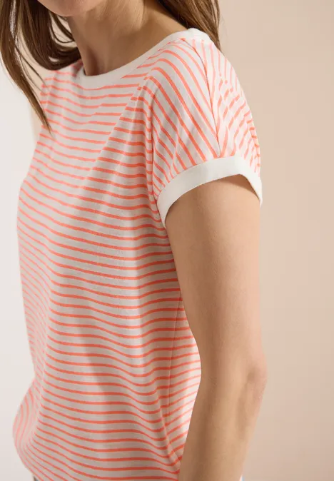 Iemand draagt een wit T-shirt met korte mouwen en fijne koraalrode horizontale strepen voor een beige achtergrond.