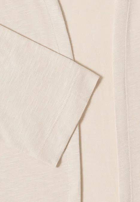 Veste ouverte en couleur unie avec manches 3/4 pearl beige Gros plan d’une veste beige texturée, aux lignes nettes et aspect doux.