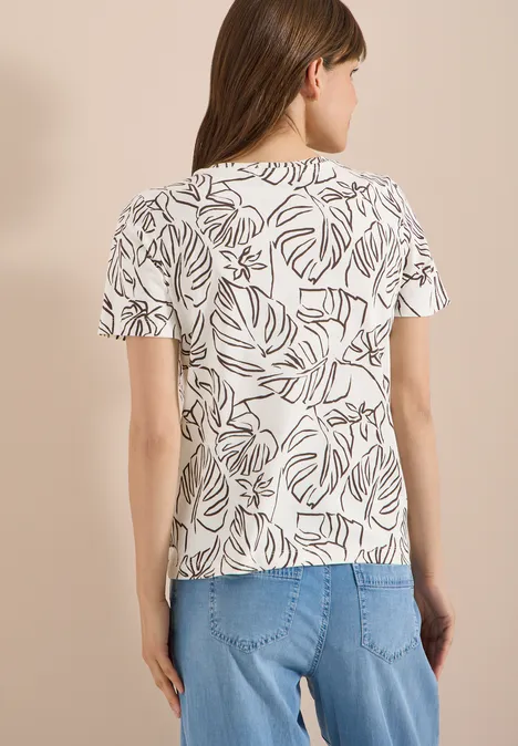 T-Shirt mit Rundhals und Blätterprint light alabaster white Frau von hinten in weißem T-Shirt mit braunem Blattmuster und blauer Jeans.