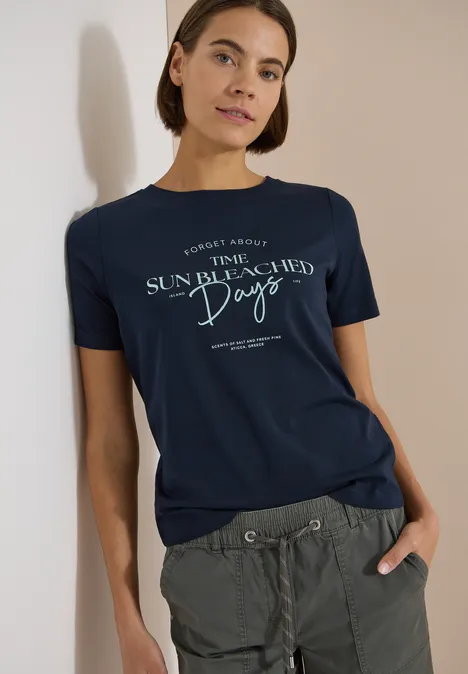 Shirt met boothals en Wording Artwork universal blue Iemand draagt een donkerblauw T-shirt met 'The Sun Bleached Days'-opdruk en een groene cargobroek.
