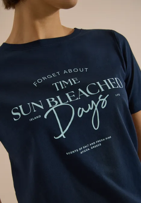 Shirt met boothals en Wording Artwork universal blue Iemand draagt een donkerblauw T-shirt met de tekst ‘Forget About Time Sun Bleached Days’.