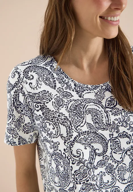 T-Shirt mit Rundhals und Muster Black Frau trägt weißes T-Shirt mit dunkelblauem Paisley-Muster, kurzärmelig und lässig.
