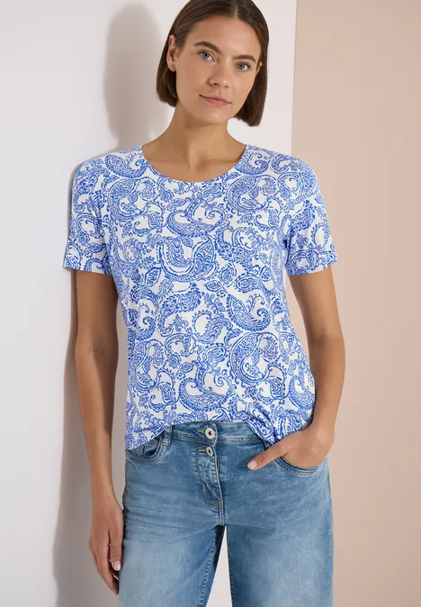 T-Shirt mit Rundhals und Muster vanilla white Frau in blau-weißem Paisley-T-Shirt und blauen Jeans.