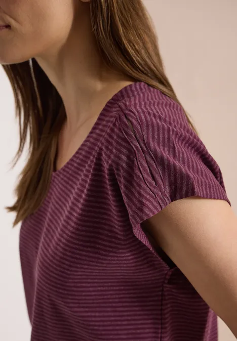 Close-up van vrouw in paars gestreept T-shirt, enkel schouder en hals zijn zichtbaar.
