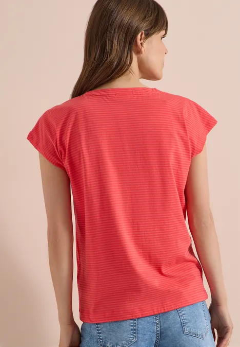 Frau von hinten in rotem, gestreiftem T-Shirt und Jeans.