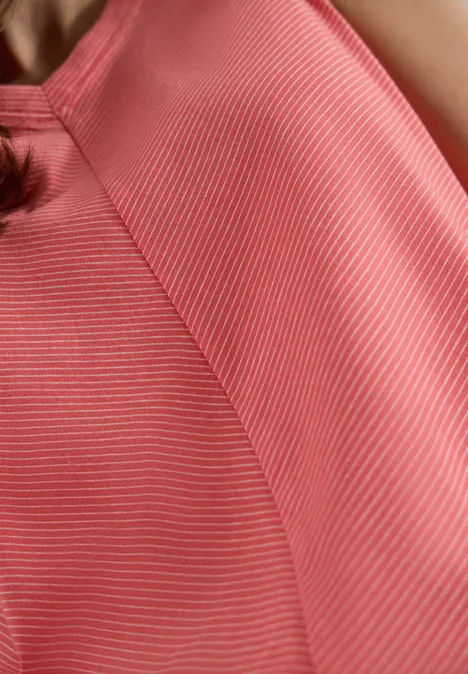 Top mit V-Neck und Streifen coral Nahaufnahme eines rosa-weiß gestreiften Tops auf Schulter und Oberkörper einer Person.