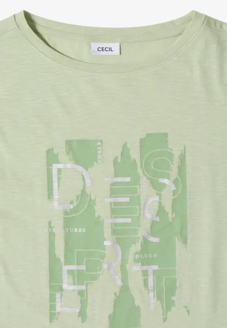 Pastellgrünes T-Shirt mit abstraktem Schriftzug und Muster vorn.