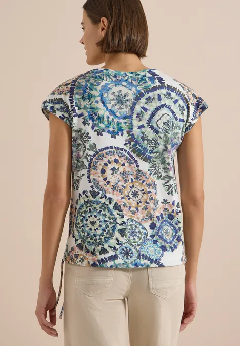 Shirt met korte mouwen, boothals en rimpels vanilla white Vrouw van achteren in een wit t-shirt met kleurrijke mandala-cirkels en een beige broek.
