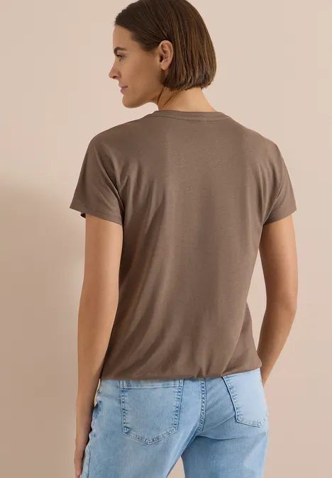 T-Shirt mit Split Neck in Unifarbe urban taupe Frau von hinten in braunem T-Shirt und hellblauen Jeans mit dezenten Herzprägungen
