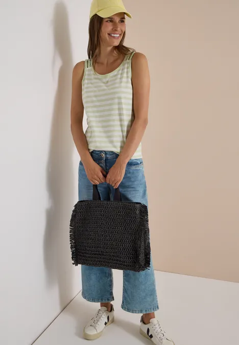 Top mit Rounded V-Neck und Streifen raw matcha lime Junge Frau mit gelber Kappe, gestreiftem Top, Jeans und weißen Sneakern hält lächelnd eine schwarze Korbtasche.