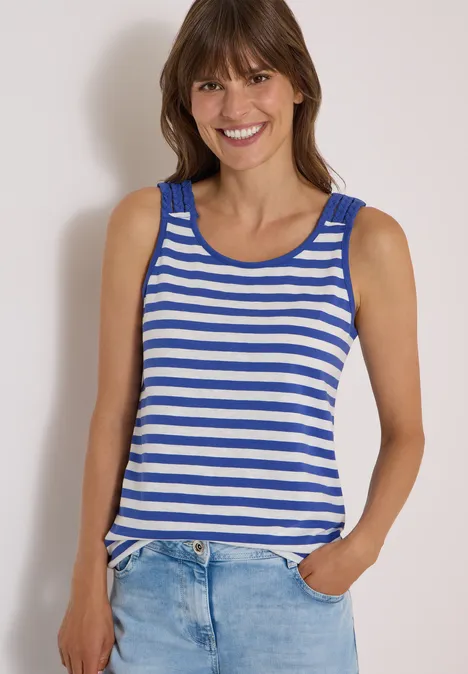 Top mit Rounded V-Neck und Streifen deep river blue Frau in blau-weiß gestreiftem Tanktop lächelt, Hand in Jeans-Tasche.