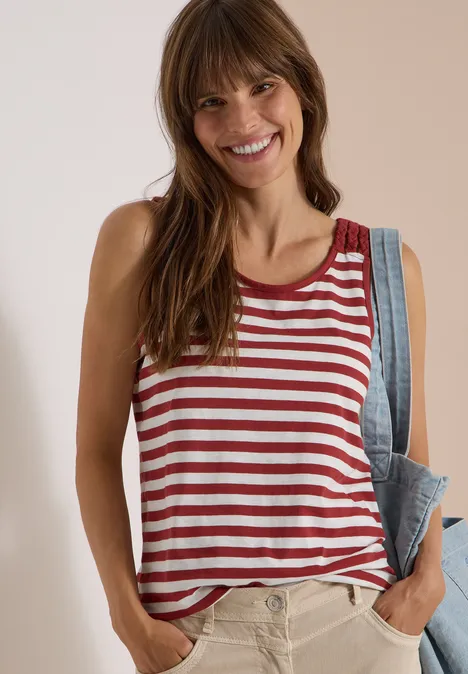 Top mit Rounded V-Neck und Streifen russet red Fröhliche Frau im rot-weiß gestreiften Tanktop, trägt eine Jeansjacke lässig über der Schulter.