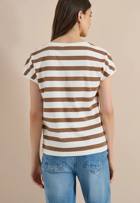 T-shirt à encolure bateau et boutons décoratifs creamy mocha Vue de dos d'une personne portant un t-shirt rayé brun et blanc et un jean bleu devant un fond beige.