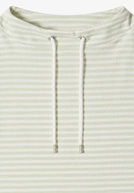 Pull léger rayé vert pâle avec cordons à l'encolure.
