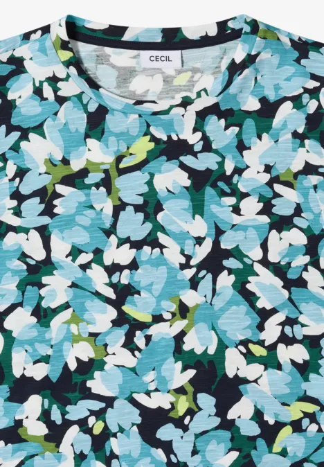 Gefaltetes Damen-T-Shirt mit blau-weiß-grünem Blumenmuster auf dunklem Hintergrund und Label 'CECIL'.