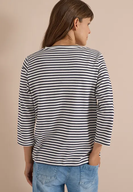 Frau von hinten in gestreiftem Shirt und Jeans.