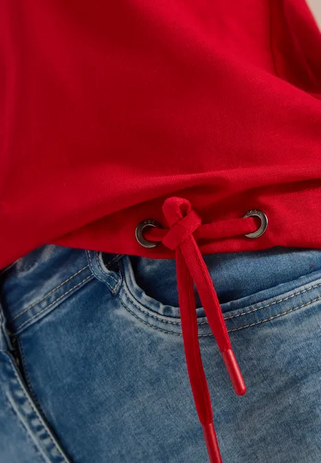 3/4-Arm Shirt mit Rundhals in Unifarbe flame red Roter Pullover mit Tunnelzug am Saum, kombiniert mit blauen Jeans.