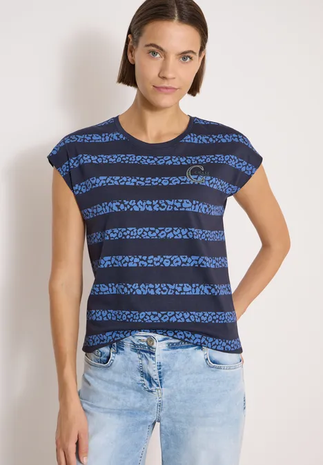 Person trägt blau-schwarz geringeltes T-Shirt und hellblaue Jeans vor weißem Hintergrund.