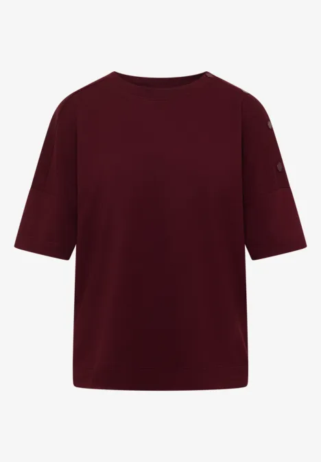 Un t-shirt bordeaux uni, col rond et manches mi-longues.