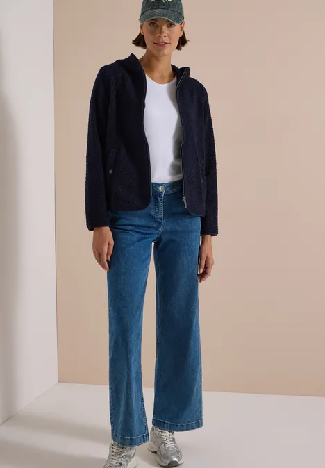 Teddy-Jacke mit Kapuze in Unifarbe urban dark blue Frau mit Baseballcap, weißem T-Shirt, dunkelblauer Jacke, weitem Jeanshose und Sneakern